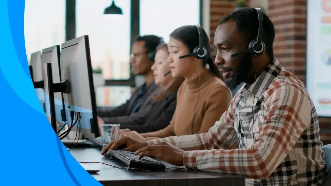 Multiple call center agents working at computer stations wearing headsets