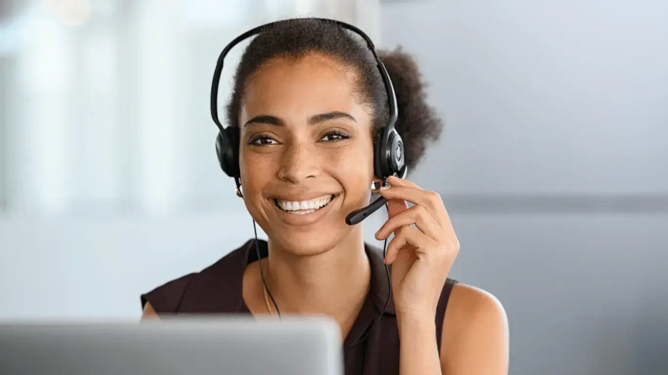 Woman with a headset looking at the camera and smiling.